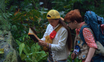 Finding 'Ohana Netflix Screenshot. Boy and girl looking at notebook in Hawaiian jungle.