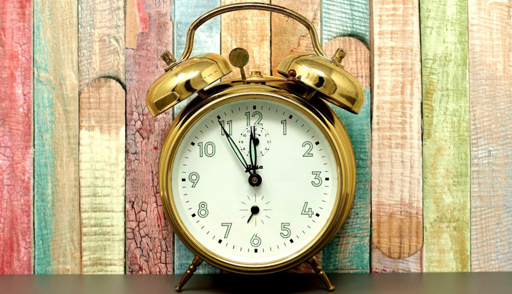 Gold alarm clock with colorful wood background