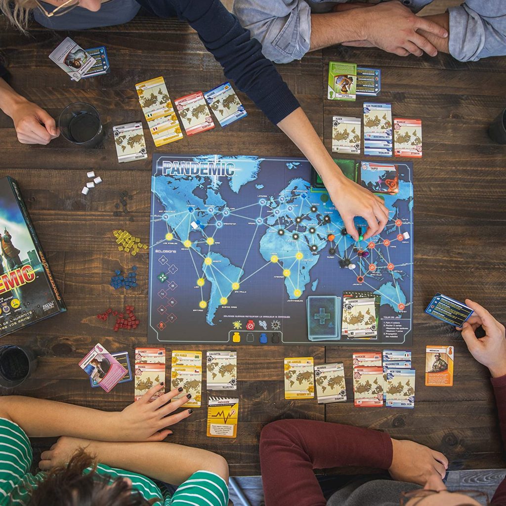 Top-down view of people playing Pandemic board game