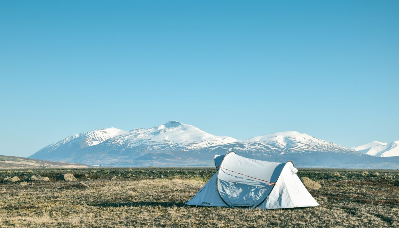 Lone white tent with snowy mountain in background