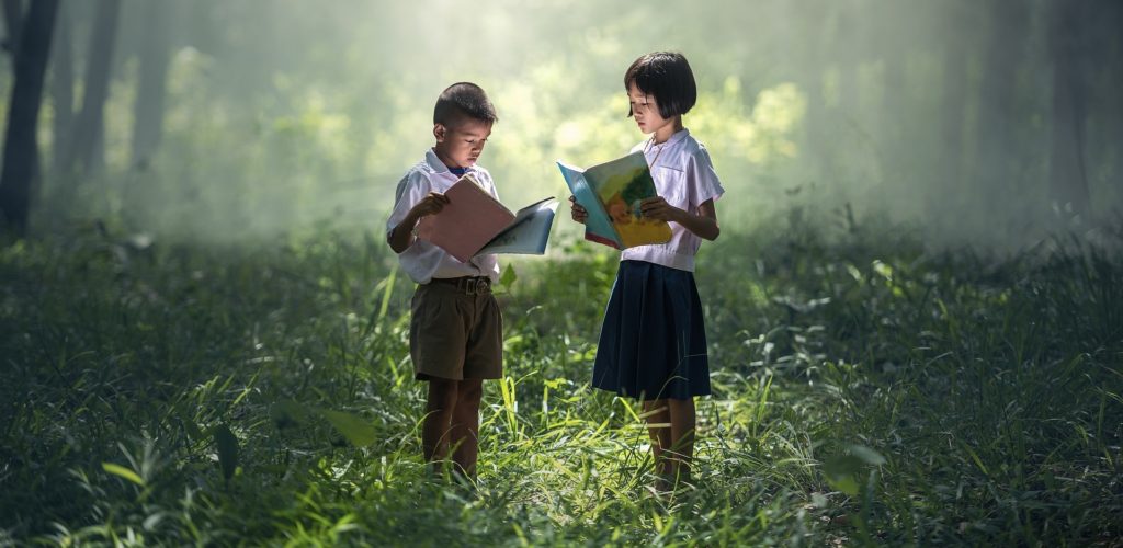 Two children reading in the forest